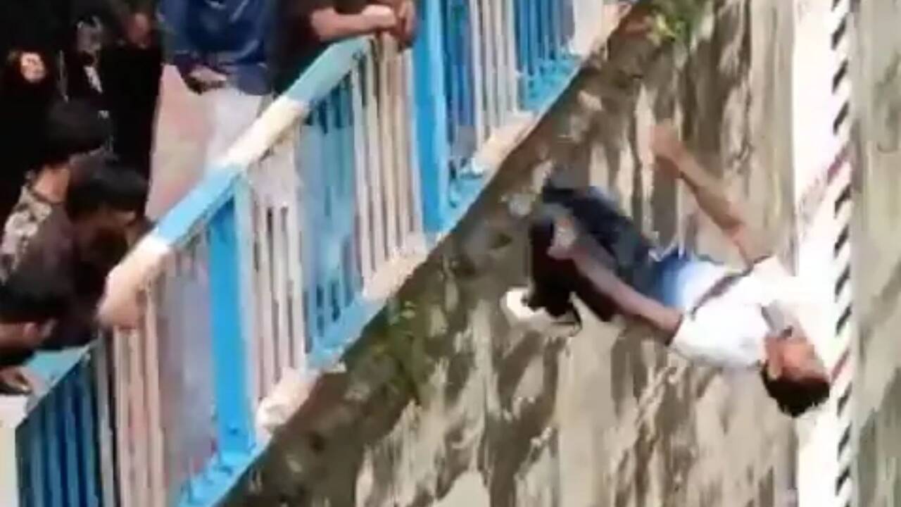Moment idiot man, 32, jumps 30ft into river for social media stunt before smashing into rocks & fracturing BOTH legs